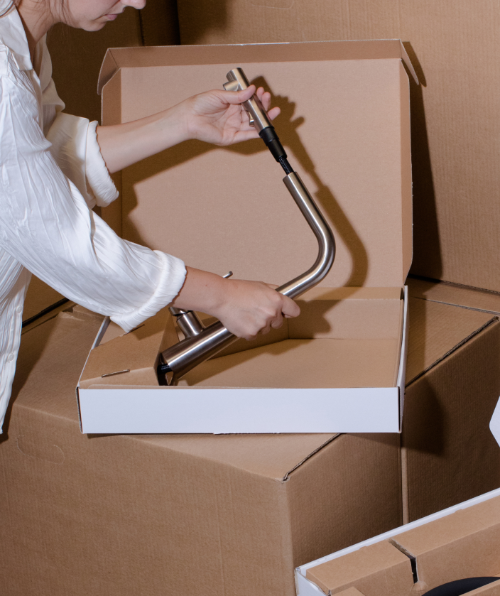 A woman packaging a kitchen tap